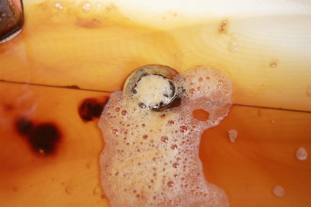 Brown water with foam around a drain